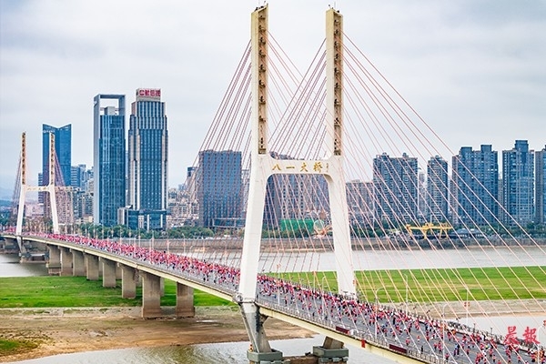 选手们从南昌地标性建筑之一的八一大桥上跑过。