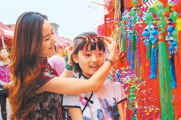 游客在庆阳香包展上选购头饰 陈飞