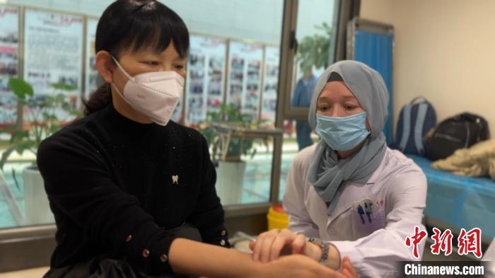 11月中旬，李峰的妻子玛丽亚(右)，作为甘肃中医药大学附属医院俄罗斯实习生，为甘肃患者把脉。王牧雨　摄