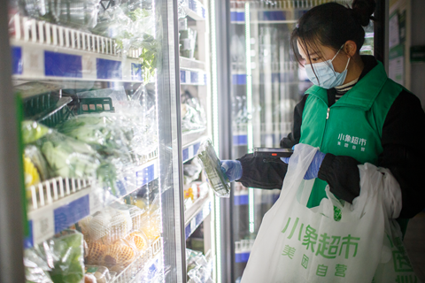 ▲美团小象超市站点内，分拣工作人员正在挑选顾客下单的商品。（拍摄：龙巍）