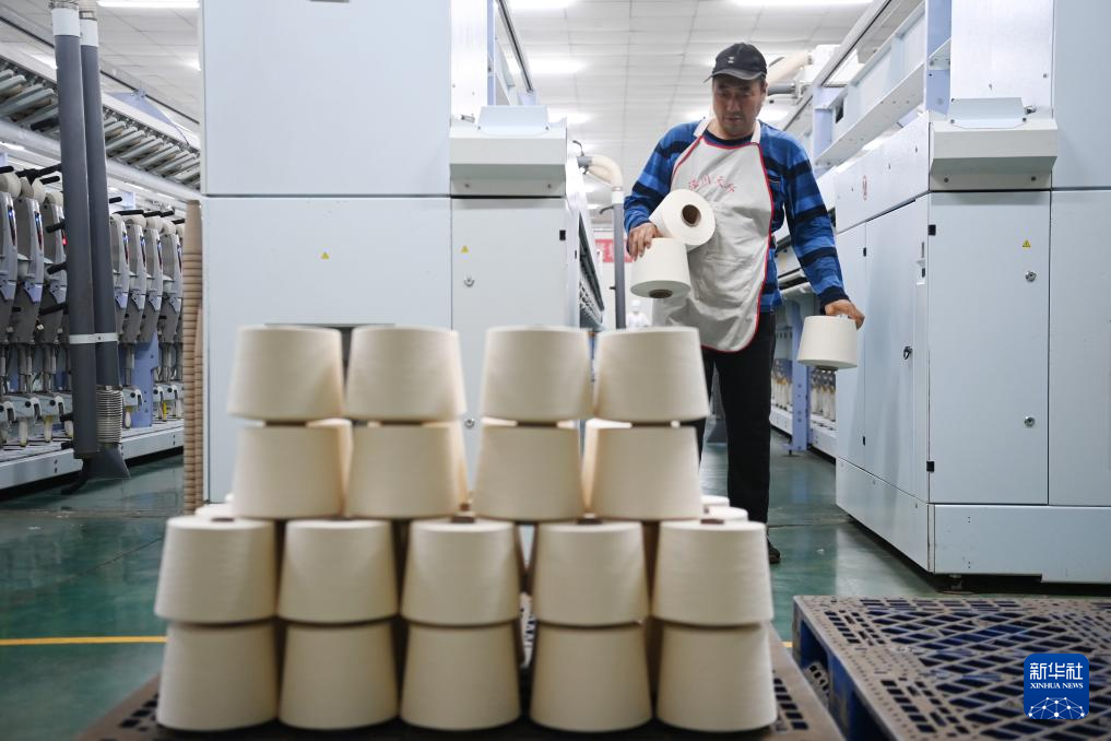 11月26日，在泾川县一家棉纱生产企业，工人搬运生产的棉纱。新华社记者　范培珅　摄