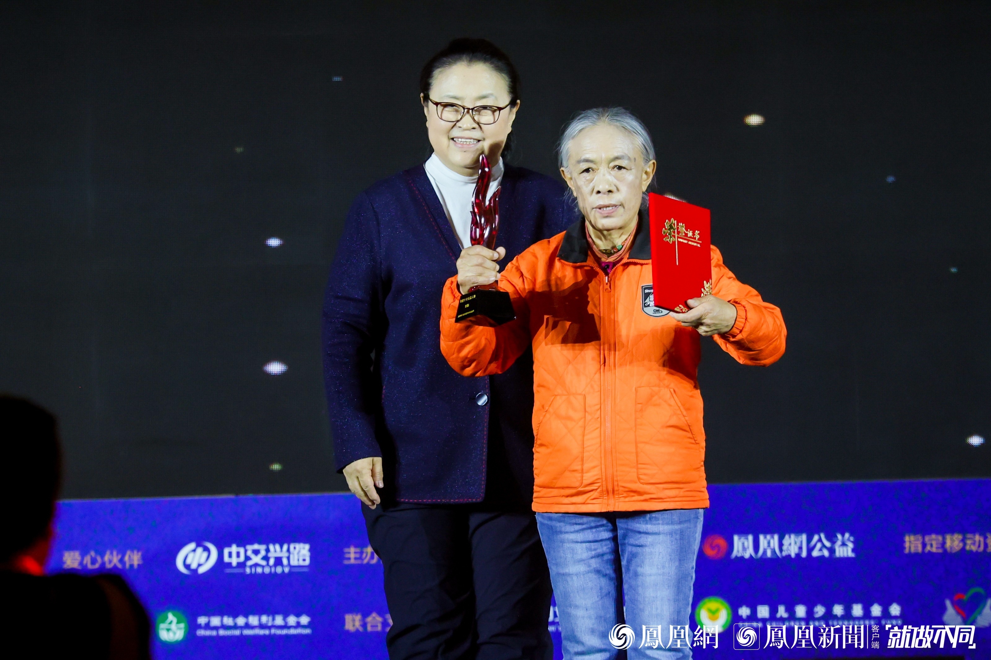 图：环保志愿者、青海省格尔木市长江源生态环境保护中心法人代表寒梅（右）获得年度十大公益人物