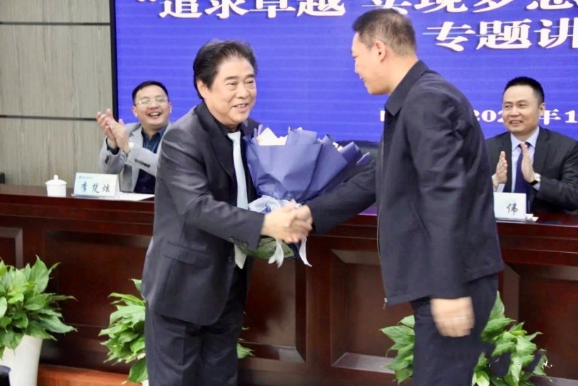 魏春纯秘书长（右）向刘洪献花致敬。
