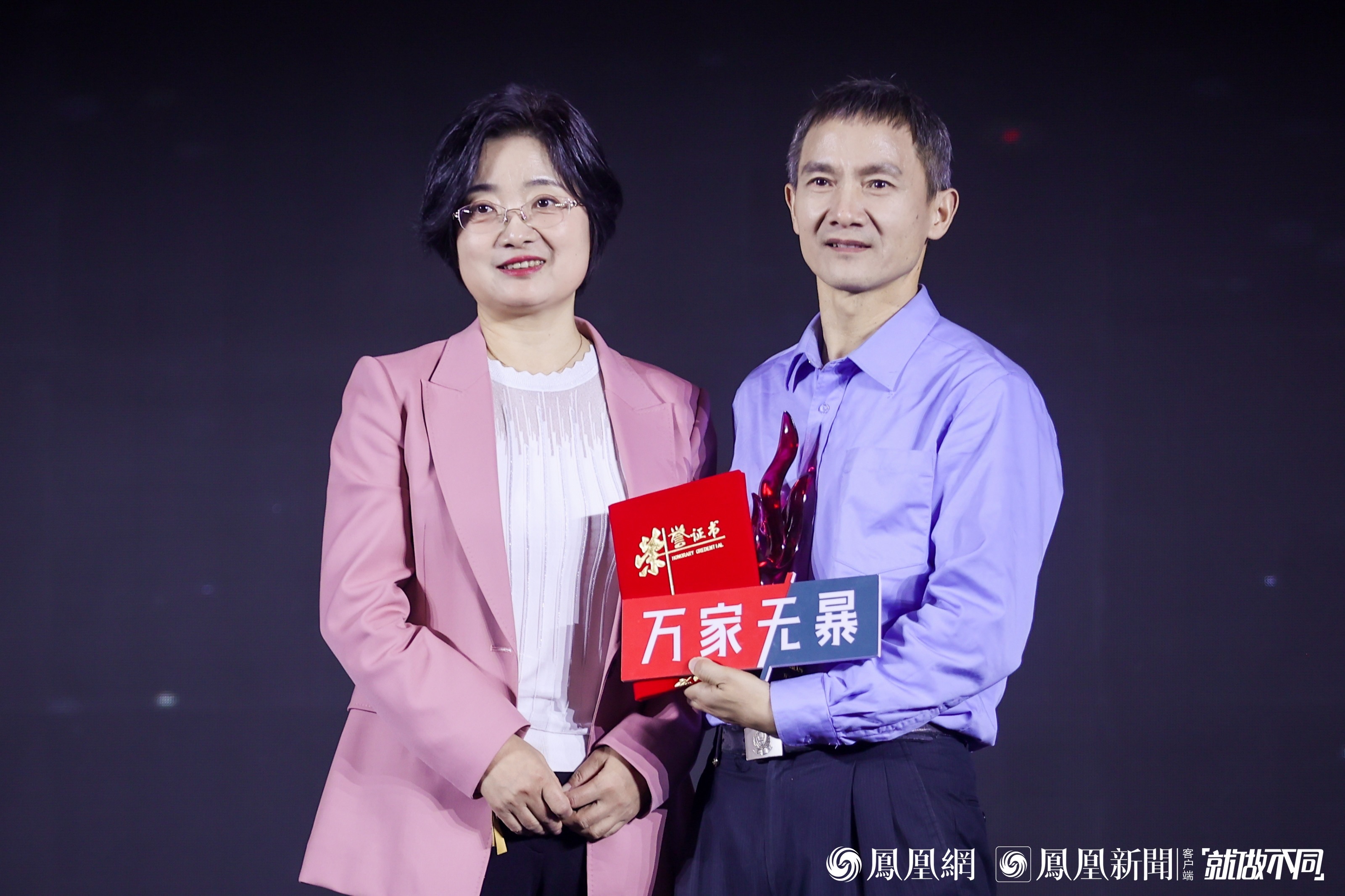 图：湖北省监利市蓝天下妇女儿童维权协会创始人万飞（右）获得年度十大公益人物