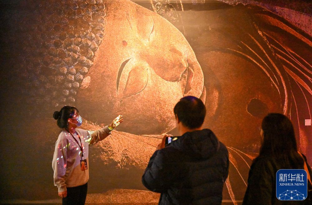 11月28日，在天津数字艺术博物馆，讲解员为参观者讲解展品。