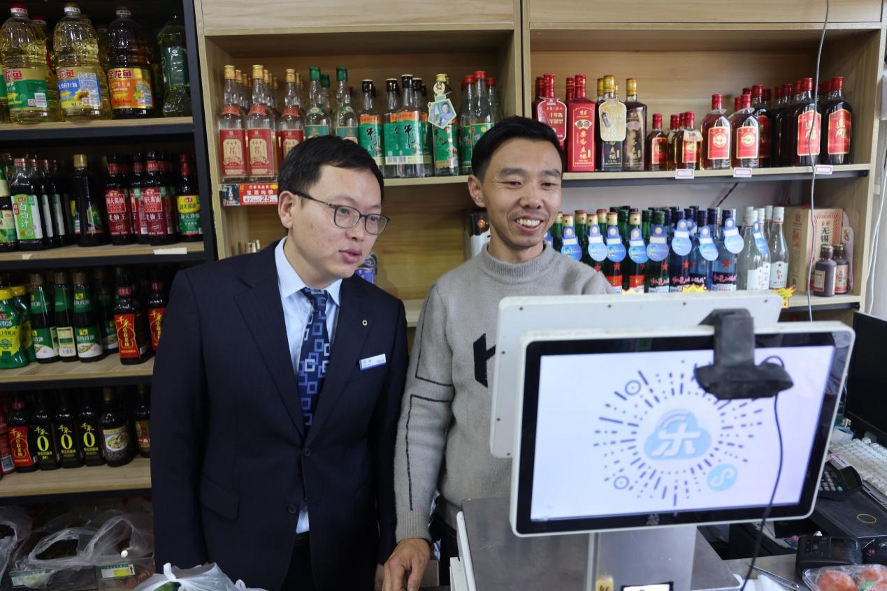 图/老板与建行客户经理分享红红火火的生意成果