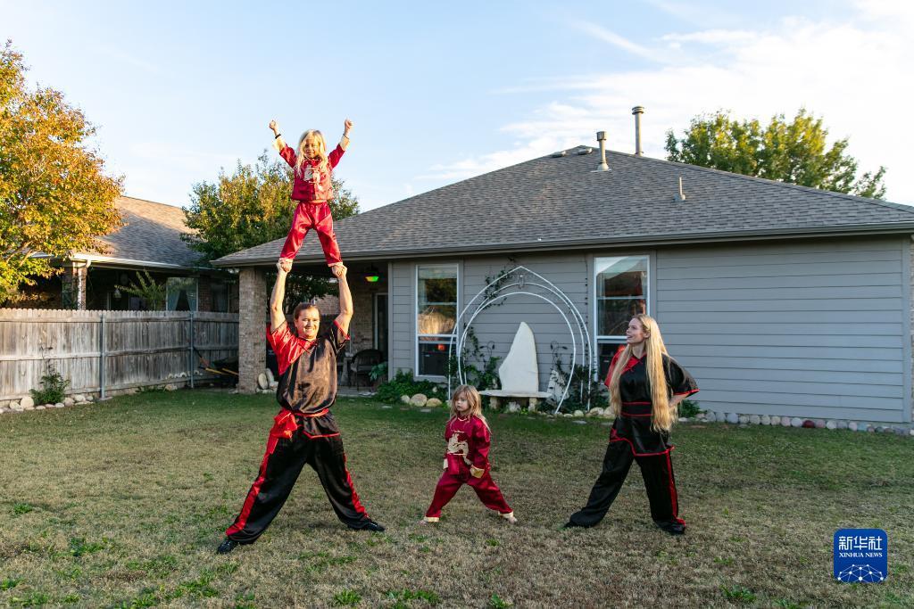 11月8日，在美国中南部得克萨斯州沃思堡，大卫&middot;绍塞多（左下）和妻子安吉拉（右）以及他们的孩子斯凯、里弗在家中后院的草坪上练武。新华社发（田丹摄）