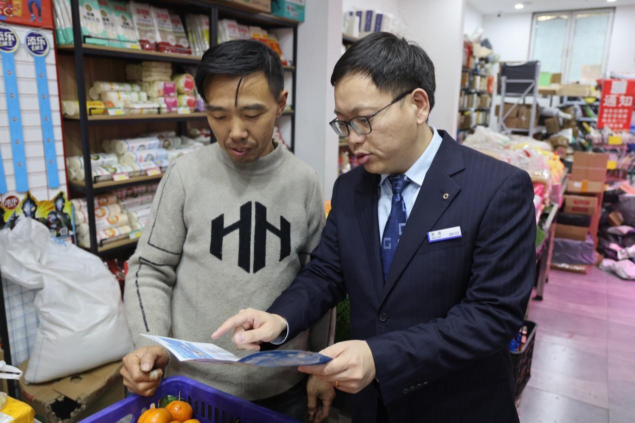 图/建行客户经理为超市老板介绍“苏农云贷”