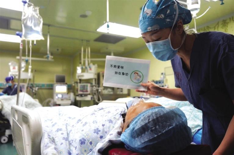 邴艳芬通过卡片与聋哑患者交流