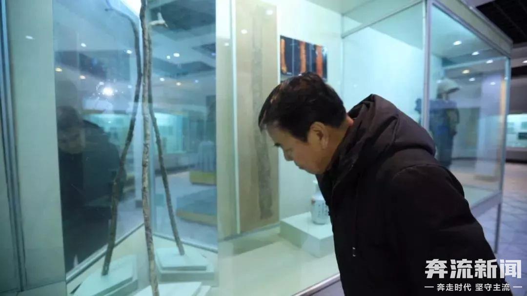 ▲李春元在瓜州博物馆八仙拐杖文物边