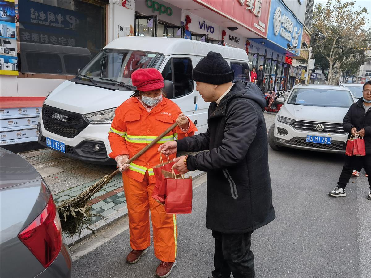 彭洋冰等3位店主，将爱心早餐送到岗位上的环卫工人手上。