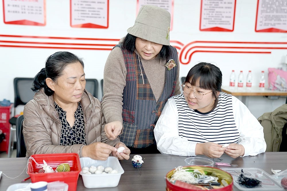 非遗传承人与体验者交流布艺纳绣技艺