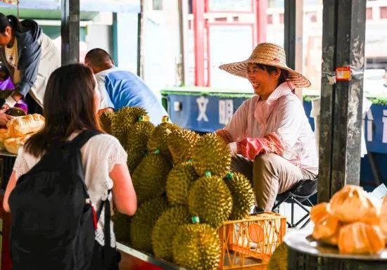 2023年5月18日,越南果商在广西东兴售卖榴莲。图源:新华社