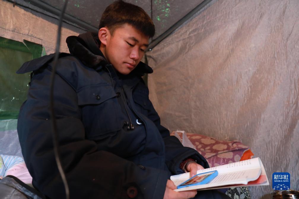 12月22日,积石山县民族中学高二学生马家浩在村里的临时安置点听课。