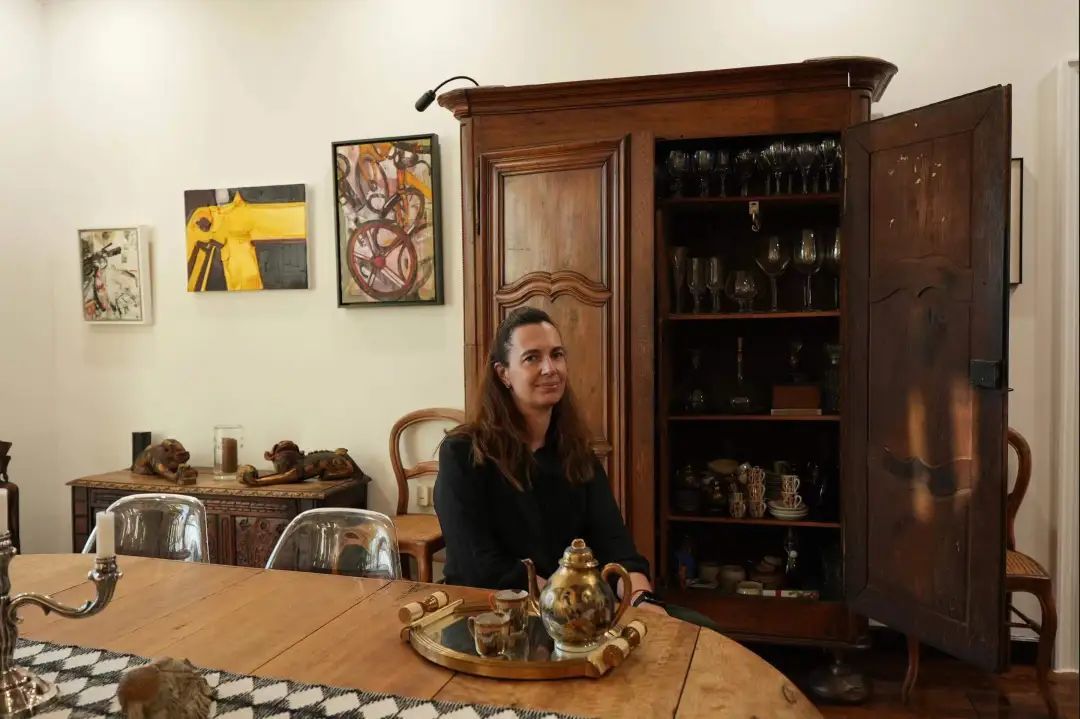 Andrea坐在桌前，桌子、茶壶、身后的柜子，都是祖父母留下的古董