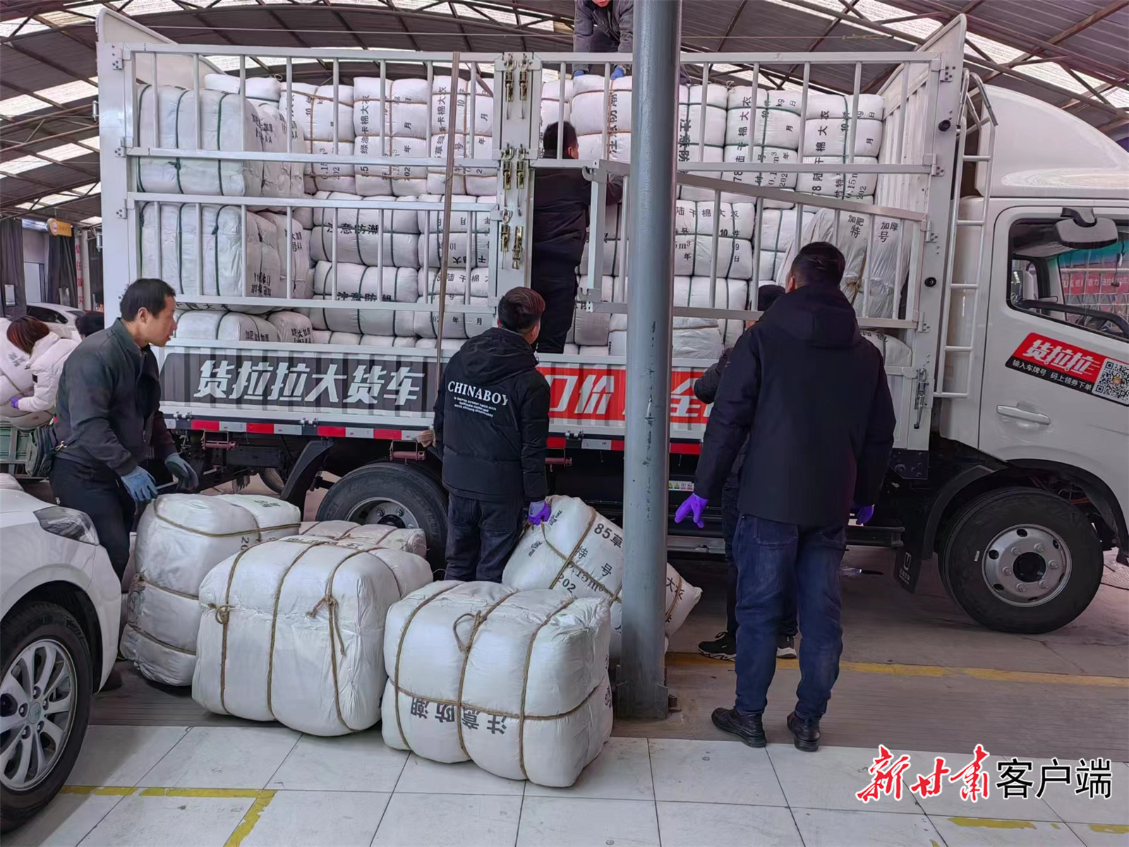 甘肃妇女儿童发展基金会筹集的棉衣、棉被、电暖气等救灾物资正在装车（省妇联供图）