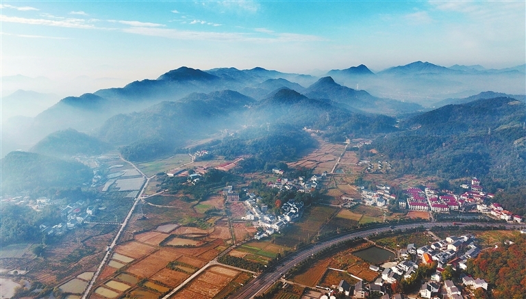 近日,万载县马步乡布城村,冬日晨光中的田园,村庄,道路,远山,与晨雾交