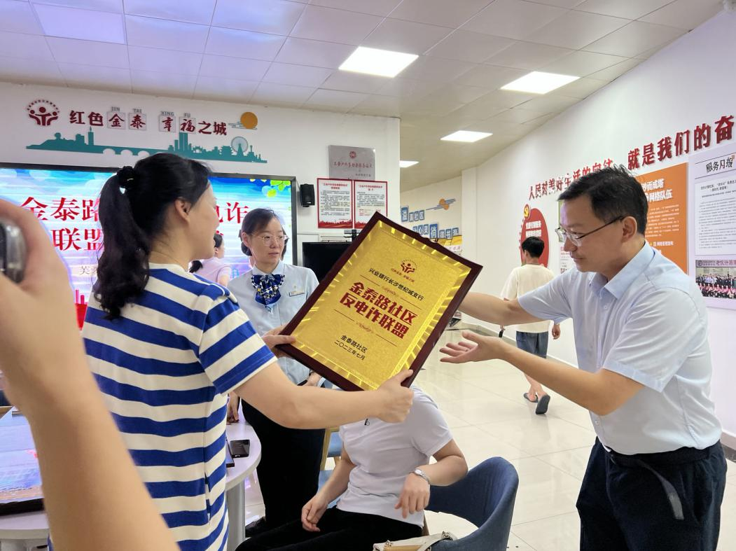 兴业银行长沙世纪城支行行长接过“反电诈联盟”牌匾