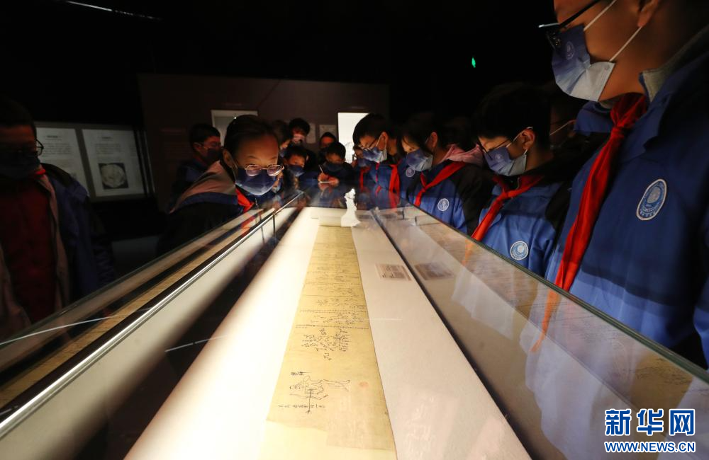 12月21日，前来参观的中学生在莫高窟藏经洞出土的唐代全天星图（复制品）展柜前驻足观看。