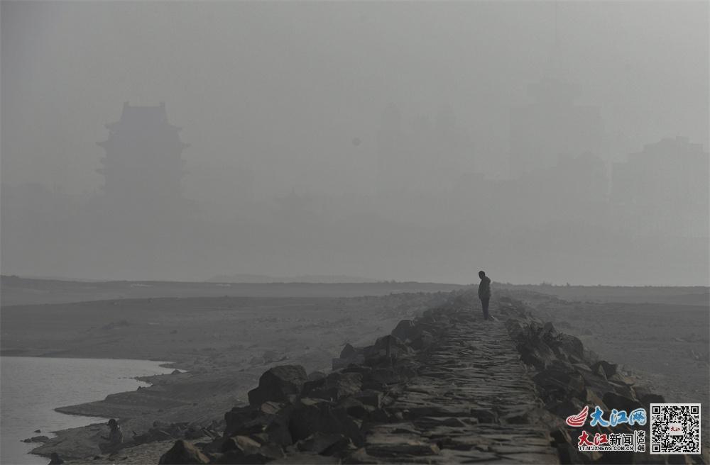 12月29日上午,镜头中赣江两岸的建筑物被雾霾笼罩。