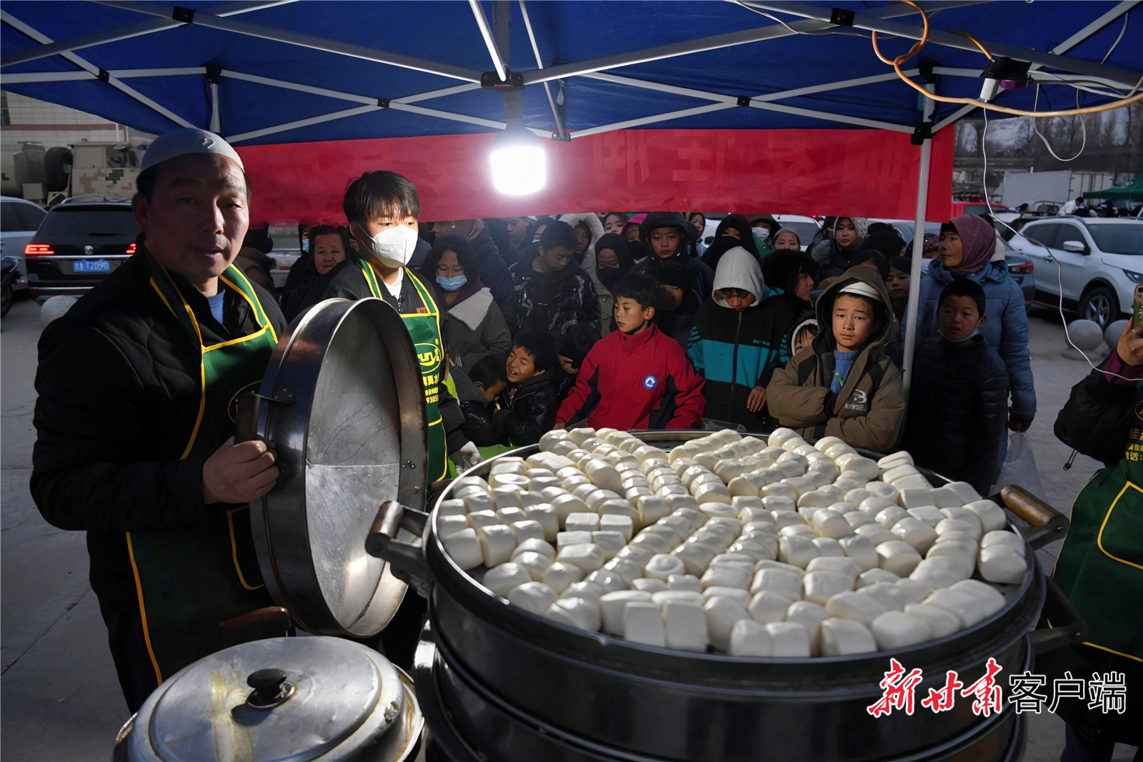 12月19日，甘肃积石山县大河村安置点，受灾群众领取热腾腾的食物。新甘肃·甘肃日报记者　郁婕