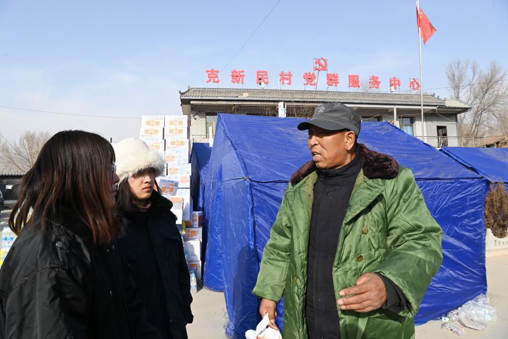 12月22日,在积石山县大河家镇克新民村安置点,党支部书记张辉林安排救灾物资发放事宜。新华社记者 范培珅 摄