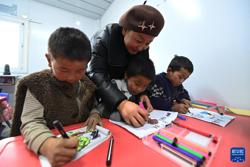 12月27日,在积石山县大河家镇梅坡小学临时教学点,老师指导小学生画画