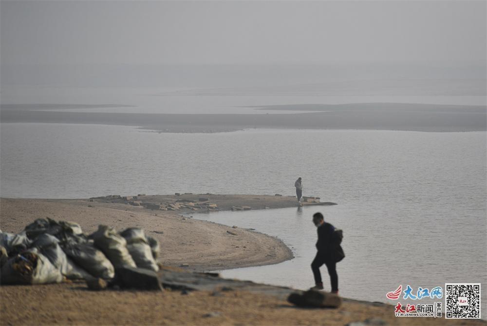 12月29日上午,镜头中赣江两岸的建筑物被雾霾笼罩。