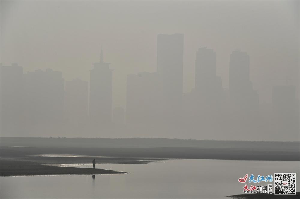 12月29日上午,镜头中赣江两岸的建筑物被雾霾笼罩。