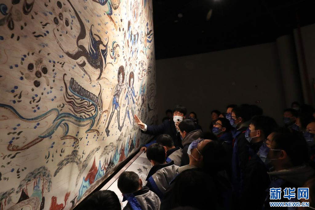 12月21日，讲解员在展览上向前来参观的中学生介绍莫高窟第285窟东披壁画（复制品）上的内容。