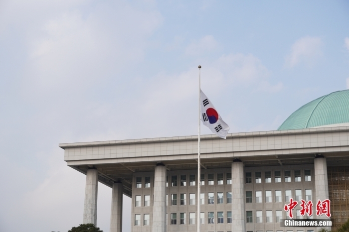 当地时间12月29日，韩国务安机场发生客机坠毁事故，机上179人遇难，2人获救。韩国政府当晚宣布，韩国即日起就客机坠毁事故进入为期7天的国家哀悼期。图为当地时间12月30日，韩国国会降半旗志哀。<a target='_blank' href='/'>中新社</a>发 张森淼 摄