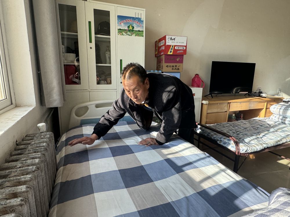 2023年12月28日，在甘肃省临夏州积石山县综合社会福利院的房间内，赵怀胜在整理床铺。新华社记者　任延昕　摄