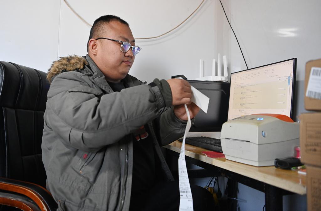 郭庆在电脑前整理发货的快递单(12月22日摄)。新华社记者李然摄