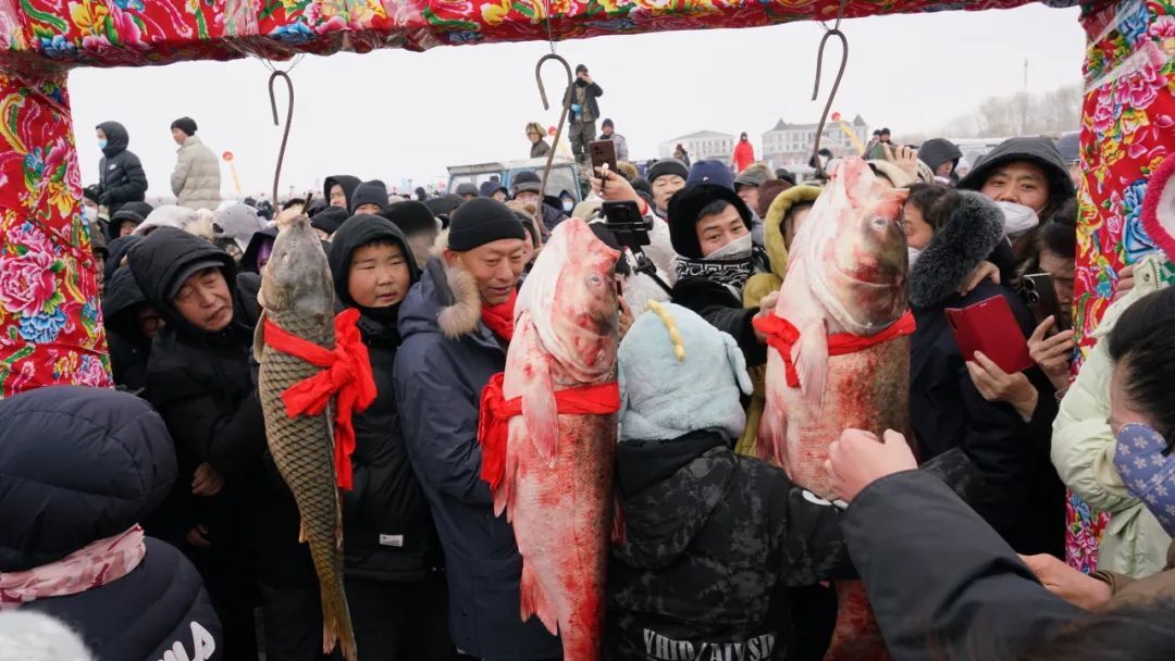 现场不仅有万斤冬捕鱼出水上岸,还就地支起铁锅炖起