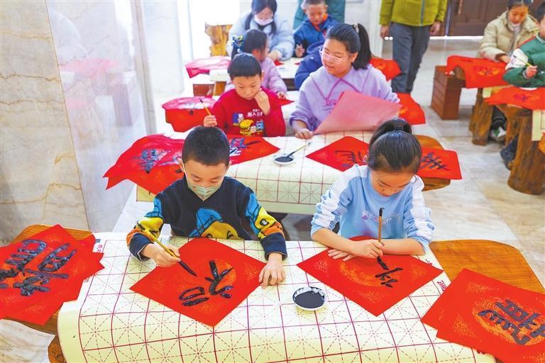 近日，在张掖市博物馆，志愿者向孩子们讲解元旦的历史和由来，让孩子们动手制作艾草香囊，练习书法迎接新年。新甘肃&middot;甘肃日报通讯员　赵琳　吴玮