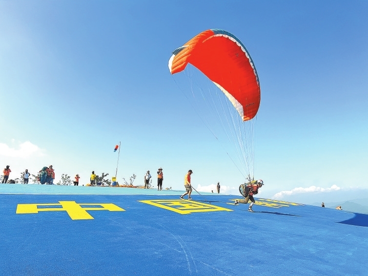 在位于赣州市南康区龙回镇布谷寨的滑翔伞基地起飞场，滑翔伞爱好者们正在此处准备起飞，享受翱翔蓝天的乐趣。图片由南康区融媒体中心提供