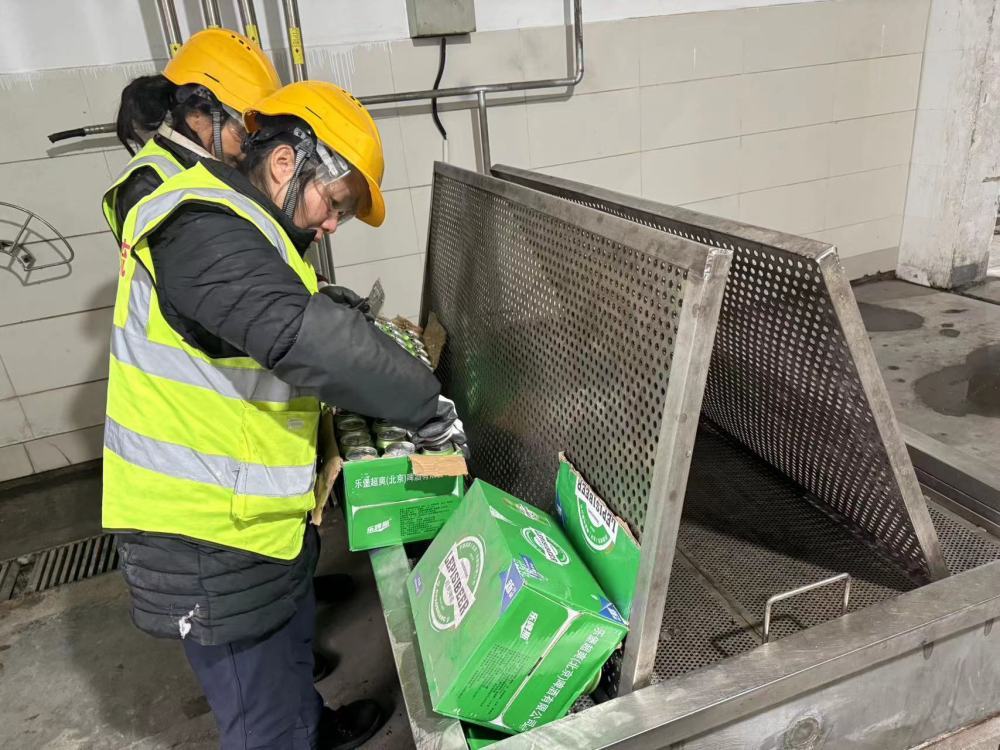 ▲工作人员对假冒伪劣啤酒进行销毁。记者 周盈 摄