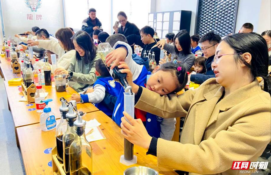 ▲在湘潭龙牌食品工业园，孩子们体验“打酱油”。