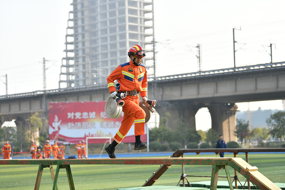 ▲参赛队员正在进行百米消防障碍项目比赛。