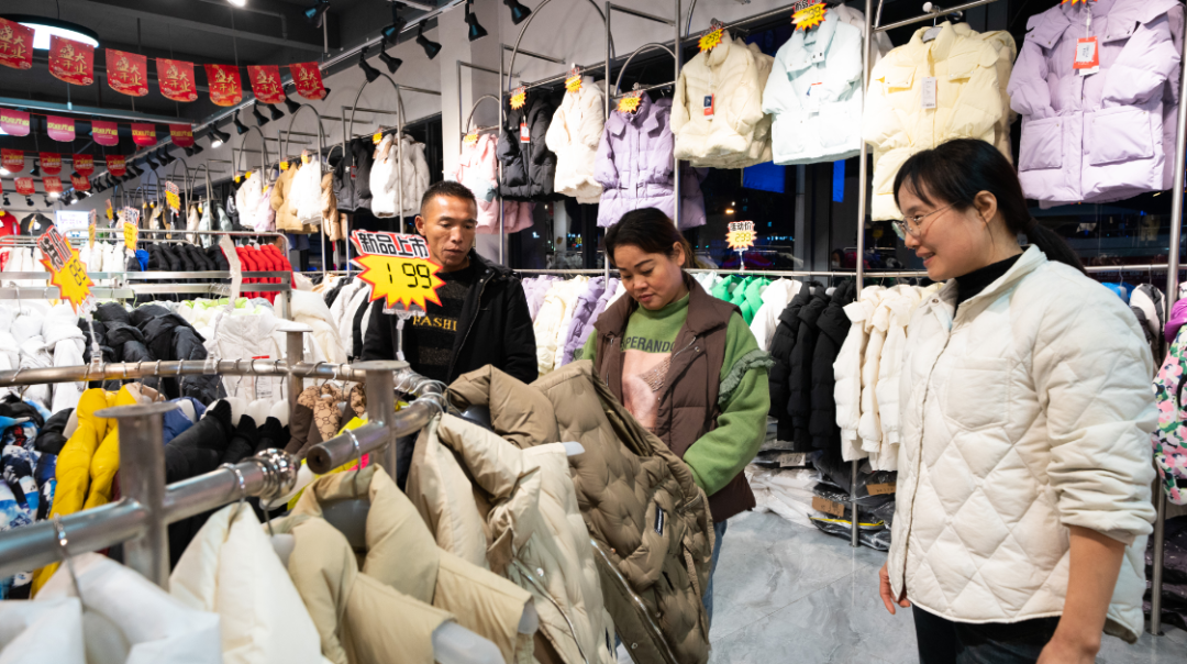 顾客在共青城服装小镇选购羽绒服