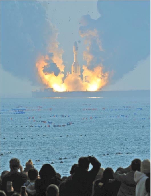 1月11日，人们在海阳市连理岛上观看海上火箭发射。（新华社记者李紫恒报道）