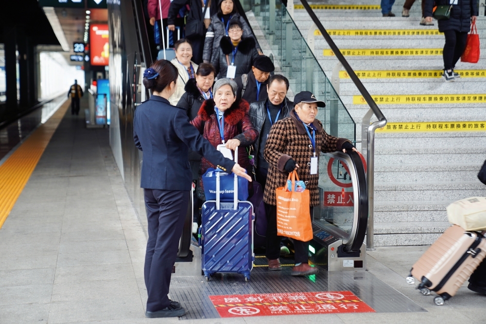 重庆北站工作人员有序引导旅客乘车。通讯员 汪亮 摄