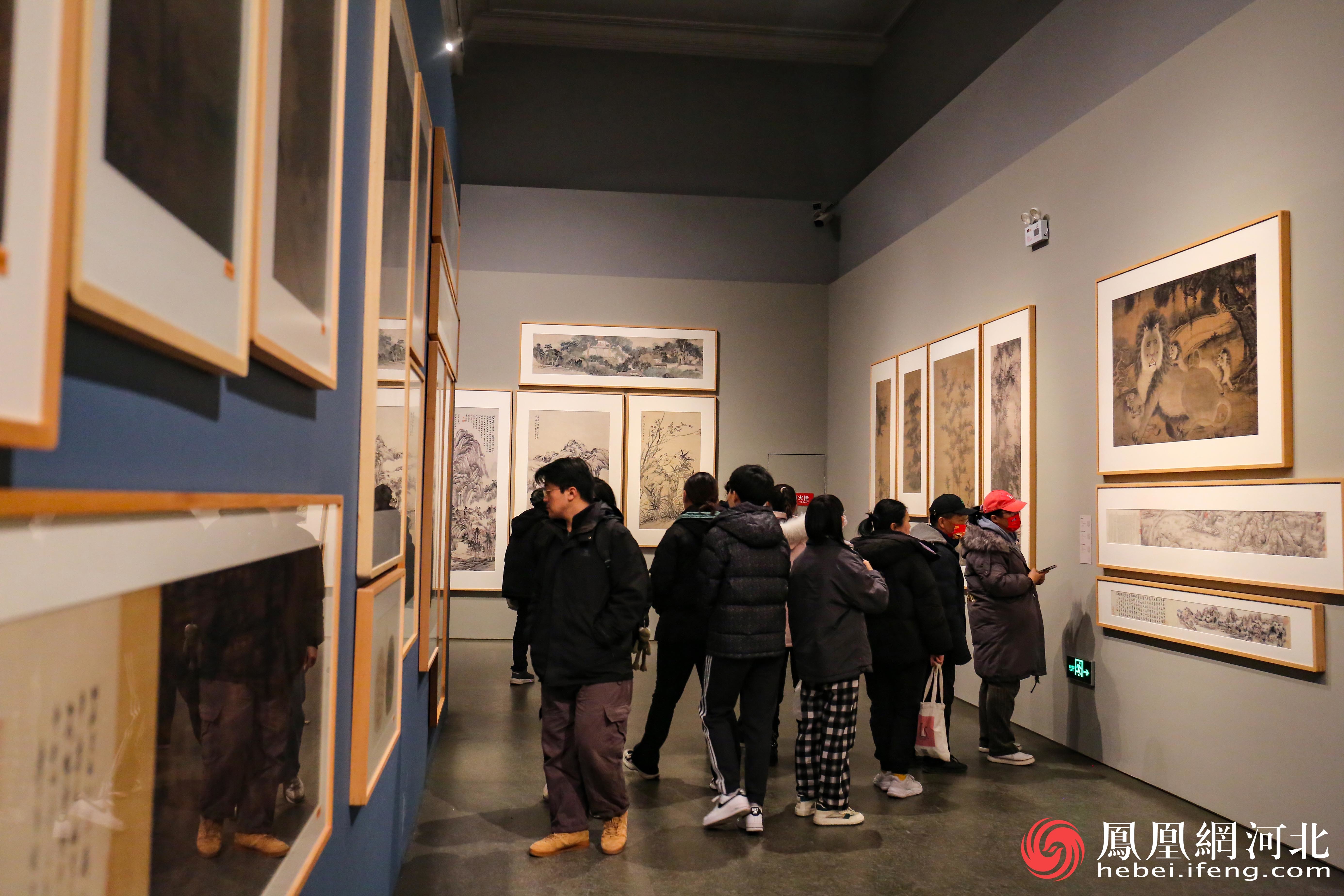参观者停步在画作前认真欣赏，感受中华文化的独特魅力。