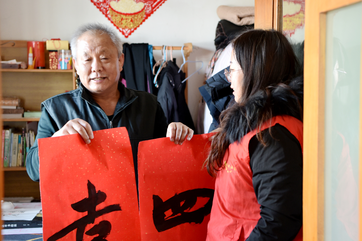 志愿者将祝福送到居民王景东家中。孙世伟摄