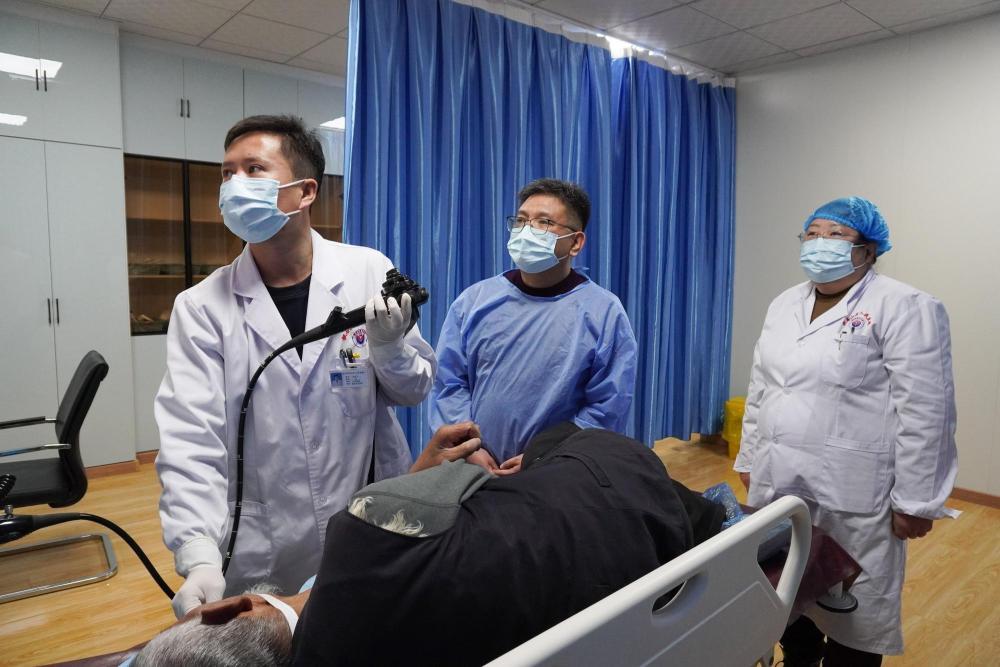 1月18日，在积石山县人民医院，山东省医疗人才“组团式”帮扶医疗队成员孔凡国（中）与本院医师一起为患者做检查。新华社记者　马希平　摄