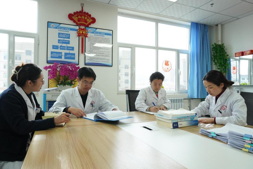 1月18日，在积石山县人民医院，山东省医疗人才“组团式”帮扶医疗队成员李燕玮（左二）、王艺（右二）和同事交流。新华社记者　马希平　摄