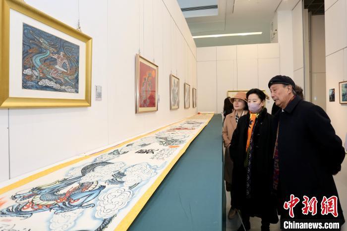 陈幼白(右一)在画展现场介绍作品.