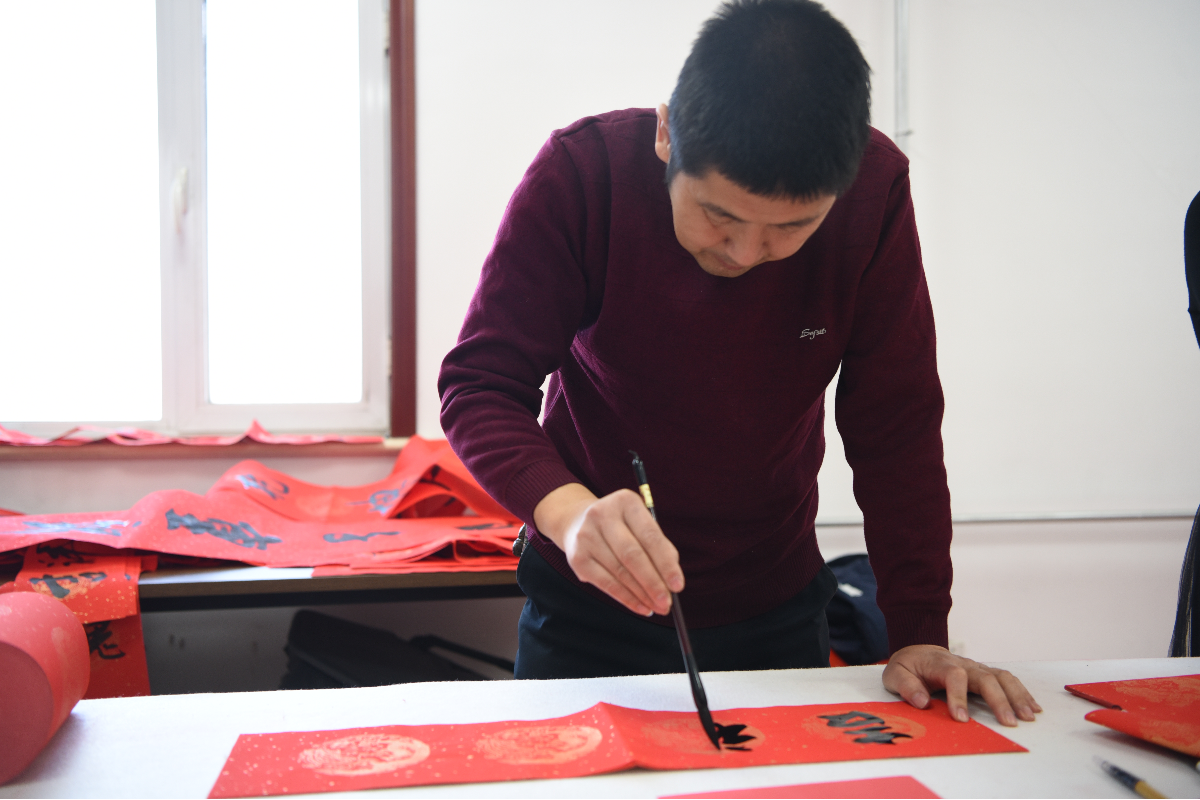 中国书法家协会会员刘果鑫为大家义务写春联。金安娜摄