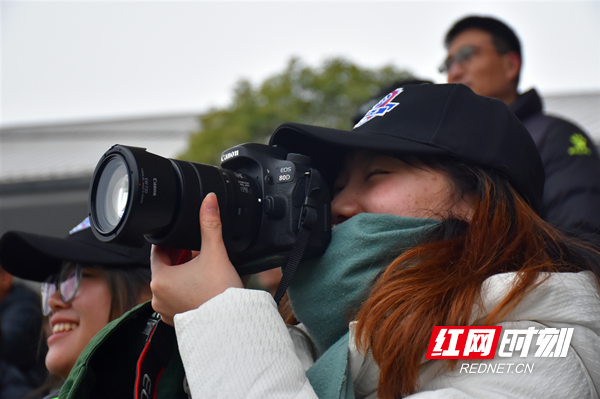 一位女球迷在用相机记录比赛精彩瞬间。摄影/符洹雨