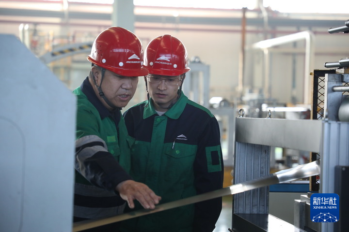 1月22日，在甘肃省金昌市金川集团镍合金有限公司内，两名工人正在进行讨论。新华社每日电讯记者　张睿　摄